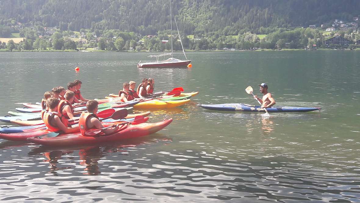 Schüler fahren mit dem Kanu am See